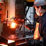 Aluminium forging process using a high-pressure hydraulic press machine in an industrial setting